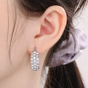 Close-up of minimalist silver titanium steel hoop earrings with sparkling rhinestones