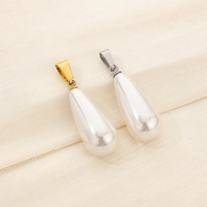 Detailed view of teardrop pearl pendants with gold and silver steel clasps on fabric