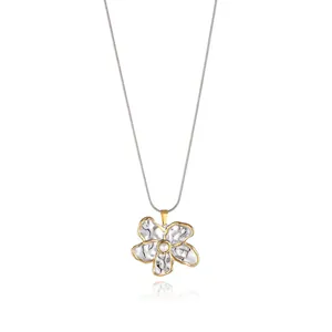 Detailed macro view of two-tone flower pendant with pearl and sleek snake chain