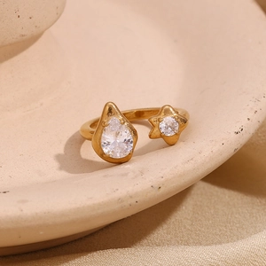 Macro detail of 18K gold-plated open ring with teardrop and star-shaped zircon stones
