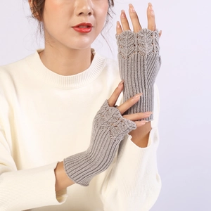Detailed knit texture of grey fingerless arm warmers with intricate hollow patterns