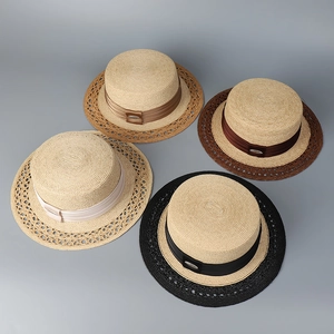 Close-up of four flat-top straw hats with satin ribbons and geometric woven patterns