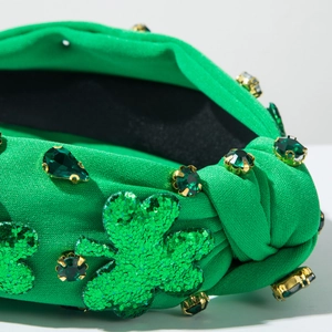 Macro view of green knotted headband with sequin shamrocks and emerald rhinestones