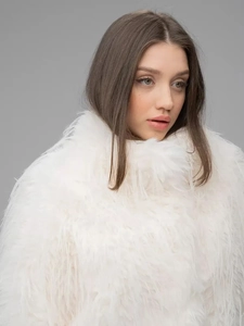 Detailed view of white faux fur coat featuring lush texture and fluffy winter style