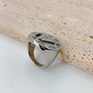 Close-up shot of a stainless steel men's ring featuring retro engraved patterns and textures
