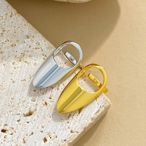 Bagues d'ongles géométriques dorées et argentées sur une pierre de travertin blanc