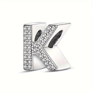 Macro detail of silver-plated letter K bead featuring intricate cubic zirconia pavé setting