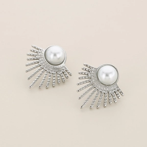 Detailed macro shot of silver sunburst fan earrings with centered pearl inlay