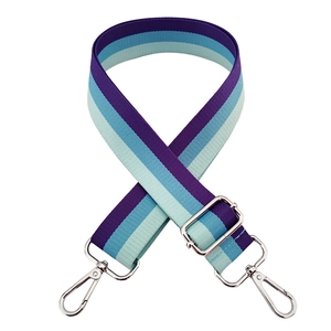 Detail of adjustable purple and blue striped nylon bag strap with silver metal swivel hooks