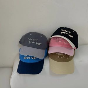Detalle del bordado don't give up en varias gorras de béisbol de algodón de colores