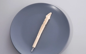 Detailed close-up of a novelty ballpoint pen shaped like an off-white human spine bone