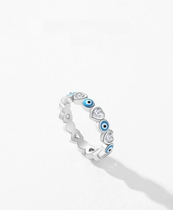 Detail of s925 silver ring featuring blue evil eye charms and heart-shaped crystals