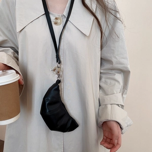 Mini sac de cou noir chic en forme de croissant en similicuir lisse sur un mannequin