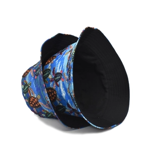 Detail of reversible bucket hat with blue turtle print and solid black inner side