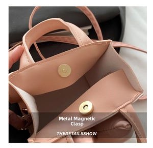 Detail view of pink leather handbag showing secure magnetic clasp and interior space