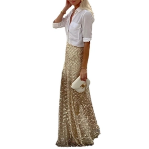 Detailaufnahme eines goldglitzernden Maxirocks mit hoher Taille und weißer Bluse