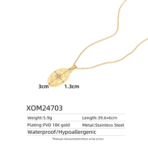 Macro view of 18K gold PVD coated stainless steel oval pendant with celestial engraving