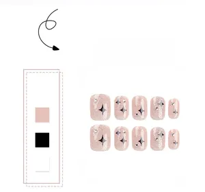 Detail view of short press-on nails with star patterns, glitter, and tiny rhinestones