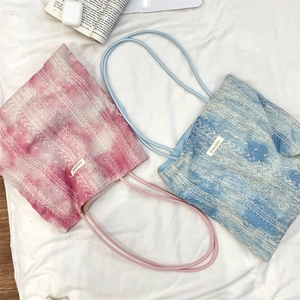 Detail of tie-dye lace tote bags in pink and sky blue with thin shoulder straps
