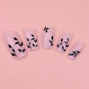 Pink press-on nails with black leaf patterns in a glossy square-round finish
