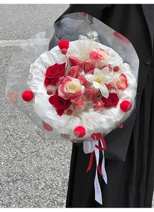 Detailed bouquet of red roses and fresh strawberries wrapped with a white ribbon
