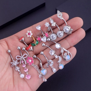 Detailed close-up of diverse zircon belly rings with heart, flower, and animal designs