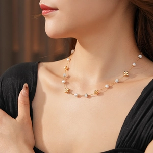 Close-up of gold flower necklace with zircon and pearl worn by a model