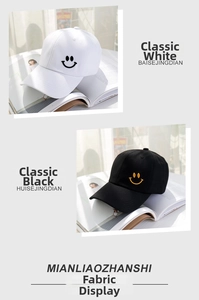 Nahaufnahme von weißen und schwarzen Baumwoll-Basecaps mit gestickten Smiley-Mustern