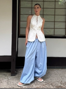Detail of light blue cotton wide-leg trousers featuring adjustable waist drawstring