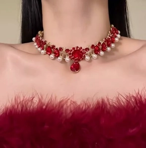 Close-up of red zircon and pearl necklace with a pear-shaped pendant on a model neck