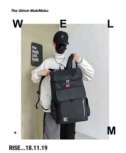 Detail of black tactical backpack with orange zippers and water-resistant fabric