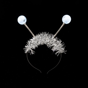 Detailed view of silver tinsel headband with light blue glitter spring balls on top