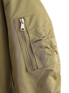 Détail de la manche d'un bomber vert armée avec poche zippée et texture en nylon brillant