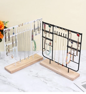 Detail of metal jewelry organizer with wooden base and multi-layer necklace hooks