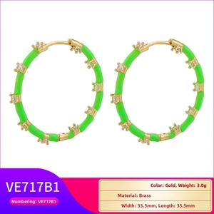 Detailed view of gold plated hoop earrings with lime green enamel and sparkling zircon stones