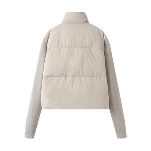 Detailed back view of a beige padded coat featuring contrast knit sleeve patchwork design