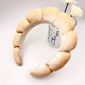 Detail of a thickened sponge headband in beige velvet with a stylish bubble wave design