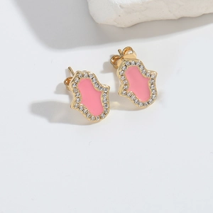 Macro detail of Hamsa earrings with gold plating, pink enamel and white cubic zirconia stones