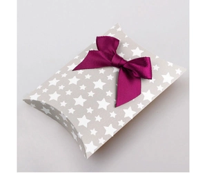 Close-up of grey star print pillow gift box with a vibrant purple ribbon bow