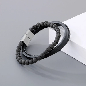 Detail of men's layered leather bracelet with lava stone beads and metal magnetic clasp