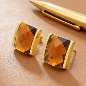 Macro shot of 18K gold plated square earrings with faceted amber glass stones