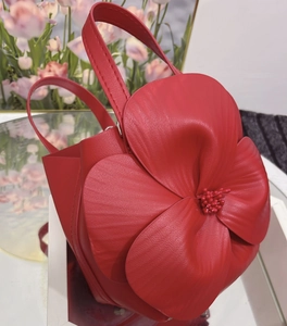 Macro shot of 3D red flower petals on a designer tote bag with high-quality leather texture