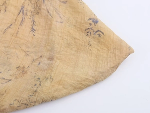 Detail of ginger yellow fabric with blue floral print and pleated texture finish
