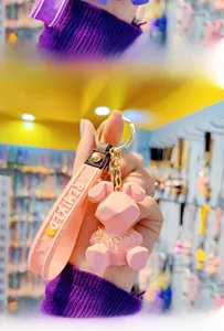 Macro detail of pink geometric resin rabbit keychain with gold chain and remixed strap