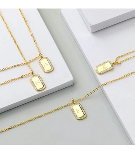 Macro shot of gold-plated rectangular letter pendants with sparkling zircon borders