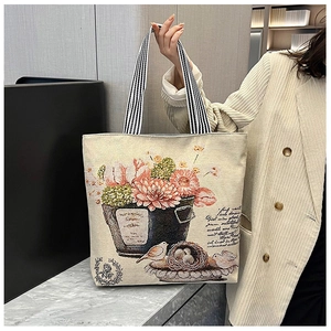 Detail of vintage floral print on beige canvas tote with striped shoulder strap