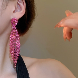 Close-up of rose pink rhinestone tassel earrings featuring a long cascading teardrop design