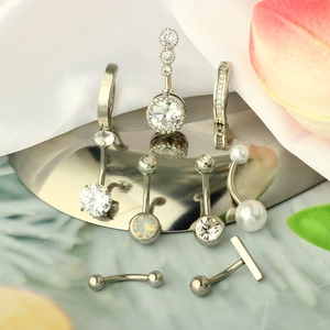 Detail view of 7-piece stainless steel belly rings with zircons on silk background