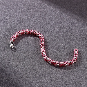 Detailed macro view of pink and silver stainless steel Byzantine chain bracelet with lobster clasp