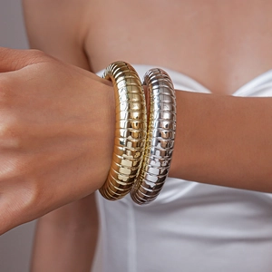 Close-up of gold and silver tubogas style bangles showing detailed metallic texture